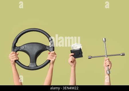 Hands holding steering wheel, wallet with money, and lug wrench on green background, car maintenance and repair costs Stock Photo