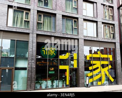 Manchester, UK - May 07, 2026: Urban minimart storefront with bold yellow signage and window reflections on a Manchester UK street. Stock Photo
