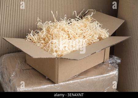 Shredded filler in box and corrugated cardboard paper, closeup. Packaging materials Stock Photo