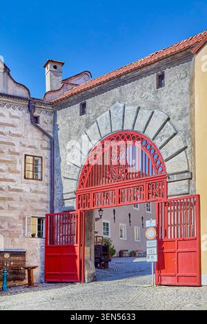 The main entrance into the Ist courtyard of the Český Krumlov castle from the town's side, Latran street, there is a wooden door called the Red Gate Stock Photo