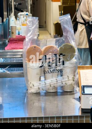 TAIPEI, TAIWAN - MAY 4, 2026: A clear plastic takeaway bag holding two sealed Daming brand tea cups sits on a stainless steel counter inside a Taiwanese tea shop, showcasing the brand's packaging and traditional tea culture. Stock Photo