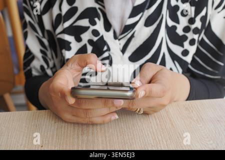 woman using a smartphone in a cafe Stock Photo