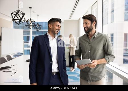 Friendly coworkers talking in modern conference room Stock Photo