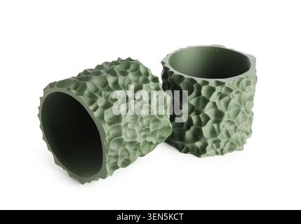 Two green 3D printed cylinders with textured surfaces, modern manufacturing and product design, the objects highlight innovative technology and the de Stock Photo