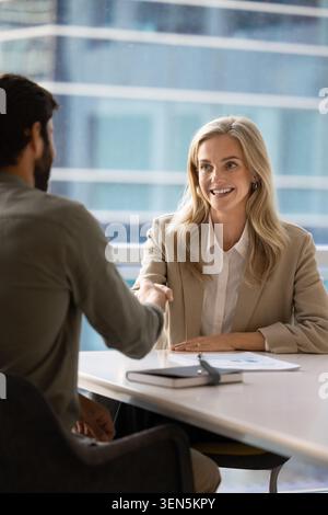 Two business partners shaking hands during meeting in office Stock Photo