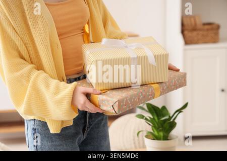 Young woman holding stack of wrapped gifts for celebration, holiday, or special occasion Stock Photo
