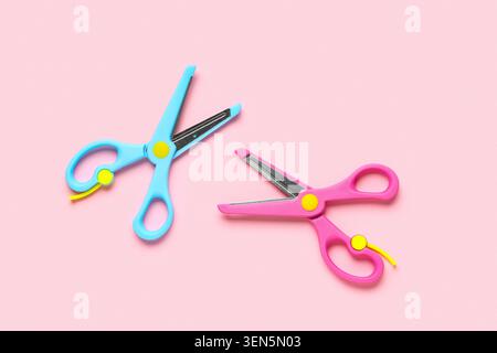 Two colorful children's safety scissors with blunt tips on pink background, crafting and school supplies Stock Photo