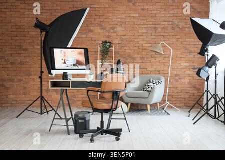 Professional photography studio setup with computer monitor displaying interior design image and lighting equipment Stock Photo