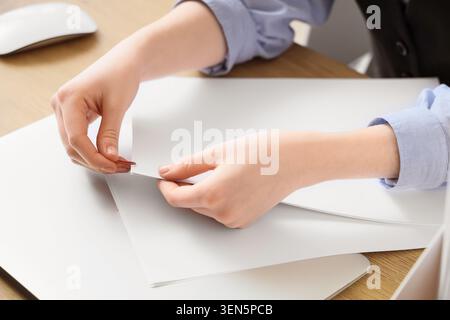 Professional businesswoman organizing documents with paper clip, office work productivity and administrative task management Stock Photo