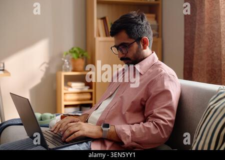 Adult Indian Man Using Laptop at Home Stock Photo