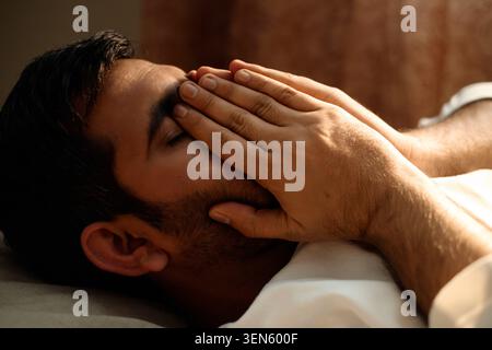 Adult Man Covering Face in Bed Showing Fatigue at Home Stock Photo