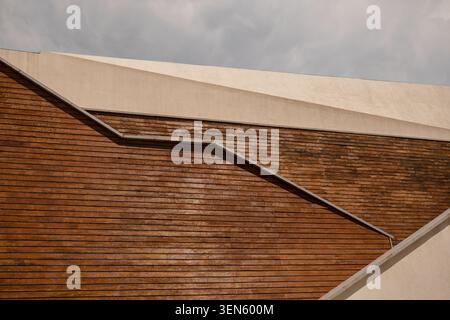 Minimalist composition featuring angled lines of wood siding and light concrete beams Stock Photo