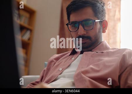 Adult Indian Remote Worker Using Laptop at Home Stock Photo