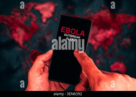 Ebola Outbreak Alert on Smartphone, A person holds a mobile phone displaying an Ebola Outbreak Alert notification on the screen against a blurred red Stock Photo