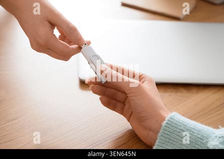 Data transfer and information sharing with USB flash drive between two people, this action represents digital communication, file exchange Stock Photo