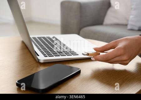 Woman's hand inserting wooden USB flash drive into laptop port for data transfer and digital storage, this action represents modern technology, connec Stock Photo