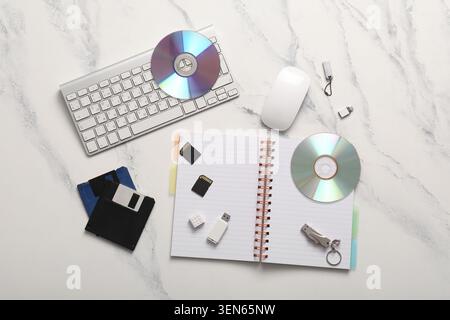Digital data storage devices and computer peripherals on white marble background, technology evolution and information management Stock Photo