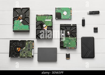Computer data storage devices collection: hard drives, SSD, USB flash drives, and memory cards on white wood Stock Photo