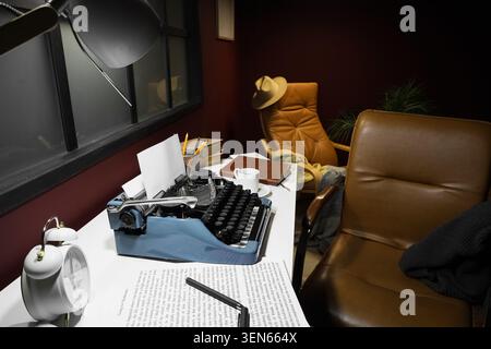 Vintage typewriter on desk with alarm clock and coffee mug, creative writing and author workspace, sense of nostalgia and focus for literary pursuits Stock Photo