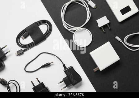 Modern electronic device charging accessories and power adapters on a clean black and white background Stock Photo