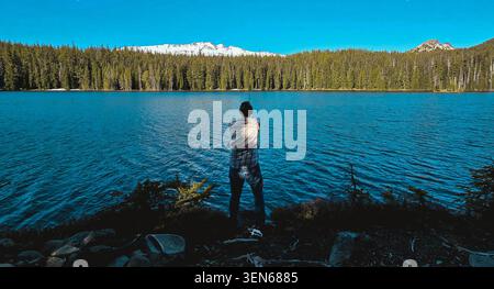 Focused Angler Casting His Line While Fishing at a High Mountain Lake Stock Photo