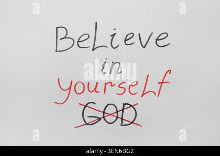 Believe in yourself motivational message with crossed out god text on white background, self-confidence and personal growth Stock Photo