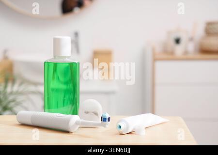 Oral hygiene products on bathroom countertop with mouthwash, electric toothbrush, toothpaste, and dental floss Stock Photo