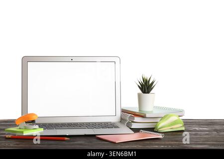 Laptop computer with blank screen, office supplies, and potted plant on wooden desk, isolated on white background Stock Photo