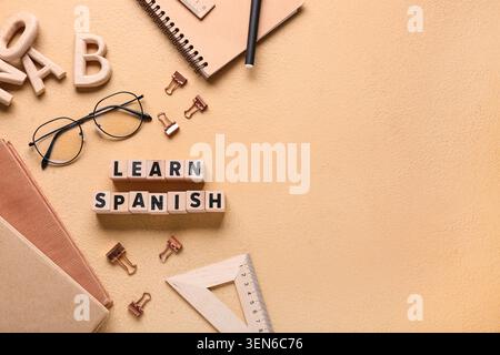Learn spanish language education with wooden blocks, books, and school supplies on textured background Stock Photo