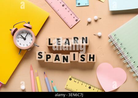 Learn spanish language education with wooden blocks, alarm clock, notebooks, and school supplies on desk Stock Photo