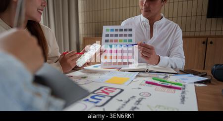 Asian business team collaborating on UI UX design creative process with color palette in modern office meeting teamwork Stock Photo
