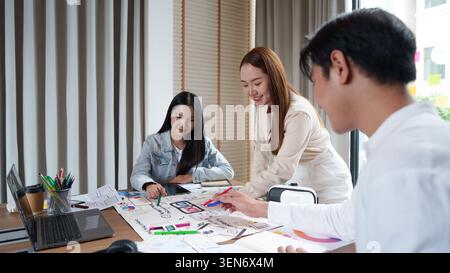 Asian business team collaborating on UI UX design creative process in modern office meeting teamwork Stock Photo