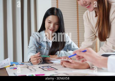 Asian business team collaborating on UI UX design creative process in modern office meeting teamwork Stock Photo