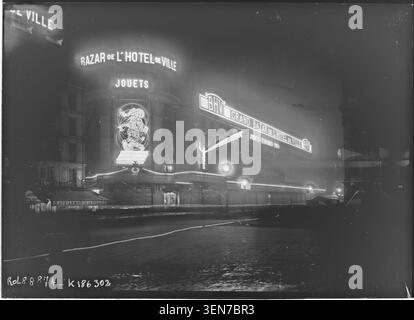 At the end of December 1923, the BHV department store on Rue du Temple in Paris is illuminated. Agence Rol recorded the press photograph featuring architectural lighting and the exterior appearance of the well-known retail building. Stock Photo