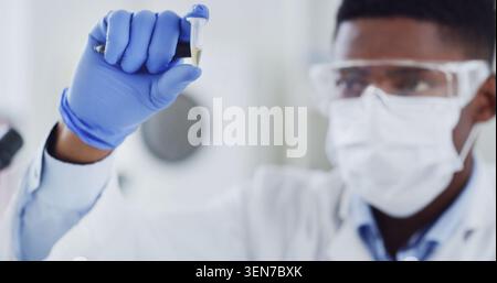 Black man, scientist and tube in lab with sample, research and experiment for medical study. Male person, face mask or inspection with safety gear for Stock Photo
