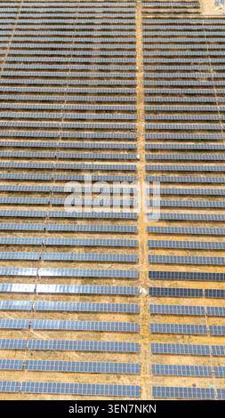 Aerial view showing rows of solar panels extending across a field, generating renewable energy in Seville, Andalucia Stock Photo