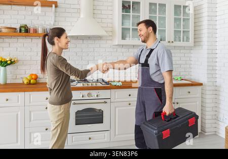 Plumber service, professional worker, female client deal hand shake after he repairs pipes, fittings Stock Photo