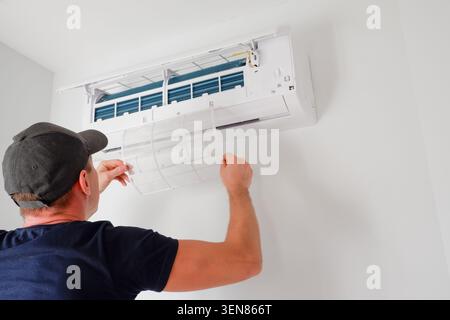 Air conditioner service. The technician checks the operation of the air conditioner. Filter replacement. Cleaning. Stock Photo