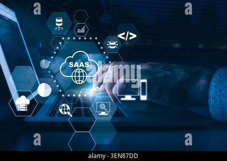 Working on SaaS applications using a laptop at night with cloud icons on the screen Stock Photo
