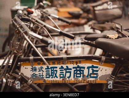 Vintage bicycles rest in a quiet cluster beside a Tokyo fish market, their worn frames and simple details carrying a strong sense of everyday life. Stock Photo