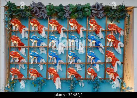 A wall display featuring dozens of traditional Japanese ornamental fish lights in a clean grid layout, Tokyo, Japan Stock Photo