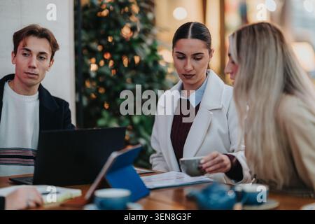 Colleagues discussing work over coffee at a casual business meeting in a cafe Stock Photo