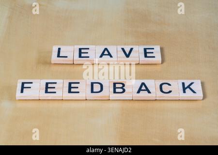 Simple wooden word tiles with Leave Feedback printed on the tile requesting that a user gives a review on a product or service Stock Photo