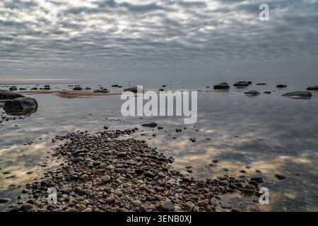 Calm Baltic Sea coast with dramatic cloud reflections near Skulte, Latvia Stock Photo
