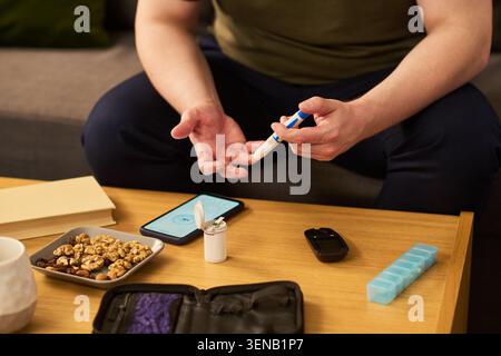 Adult Man Checking Blood Sugar with Glucose Meter at Home Stock Photo