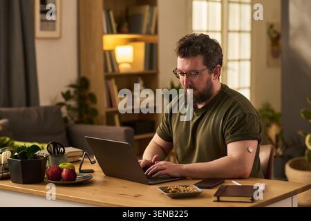 Adult Man Managing Diabetes with Health Devices at Home Stock Photo