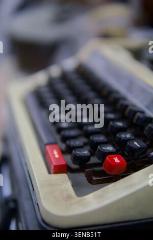 Vintage typewriter with red keys gleams softly. Soft focus highlights worn keys and classic design. Nostalgic feel evokes old-school writing and creat Stock Photo