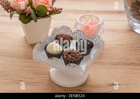 Brigadeiro arrangement on stand. Soft natural light accentuates confectionery textures. Commercial uses include culinary arts, gourmet sweets and Braz Stock Photo