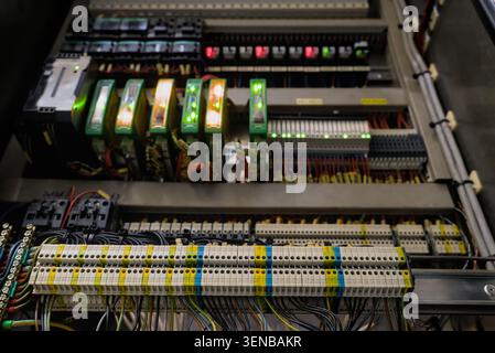 Multi tier terminal blocks with color coded wiring against blurred background of industrial control automation rack Stock Photo