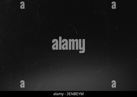 Dark grunge black film texture with dust scratches and subtle light vignette for overlay use Stock Photo